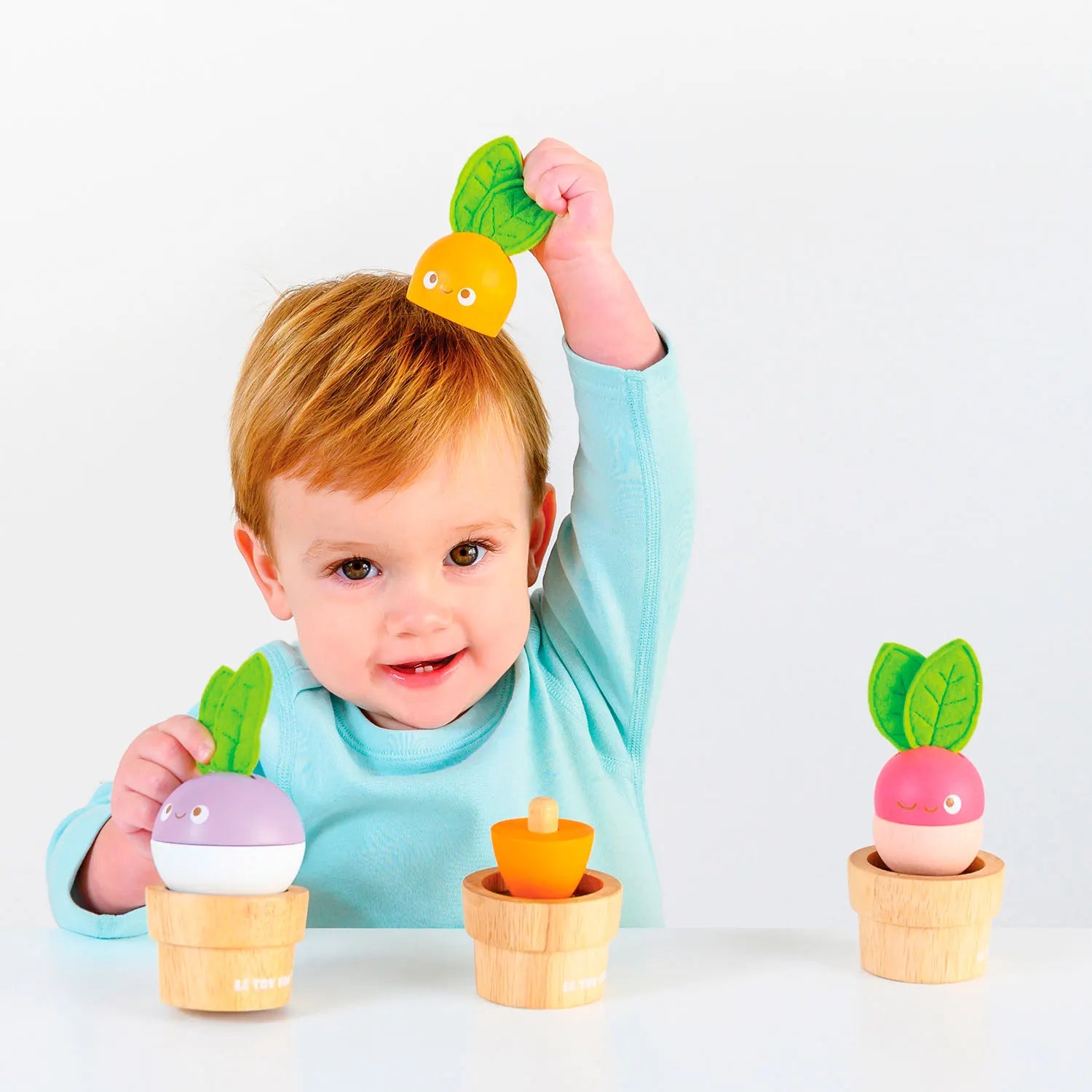 Een vrolijke set van Le Toy Van met drie soorten houtachtige groenten in natuurlijke houten potten - spelend kind